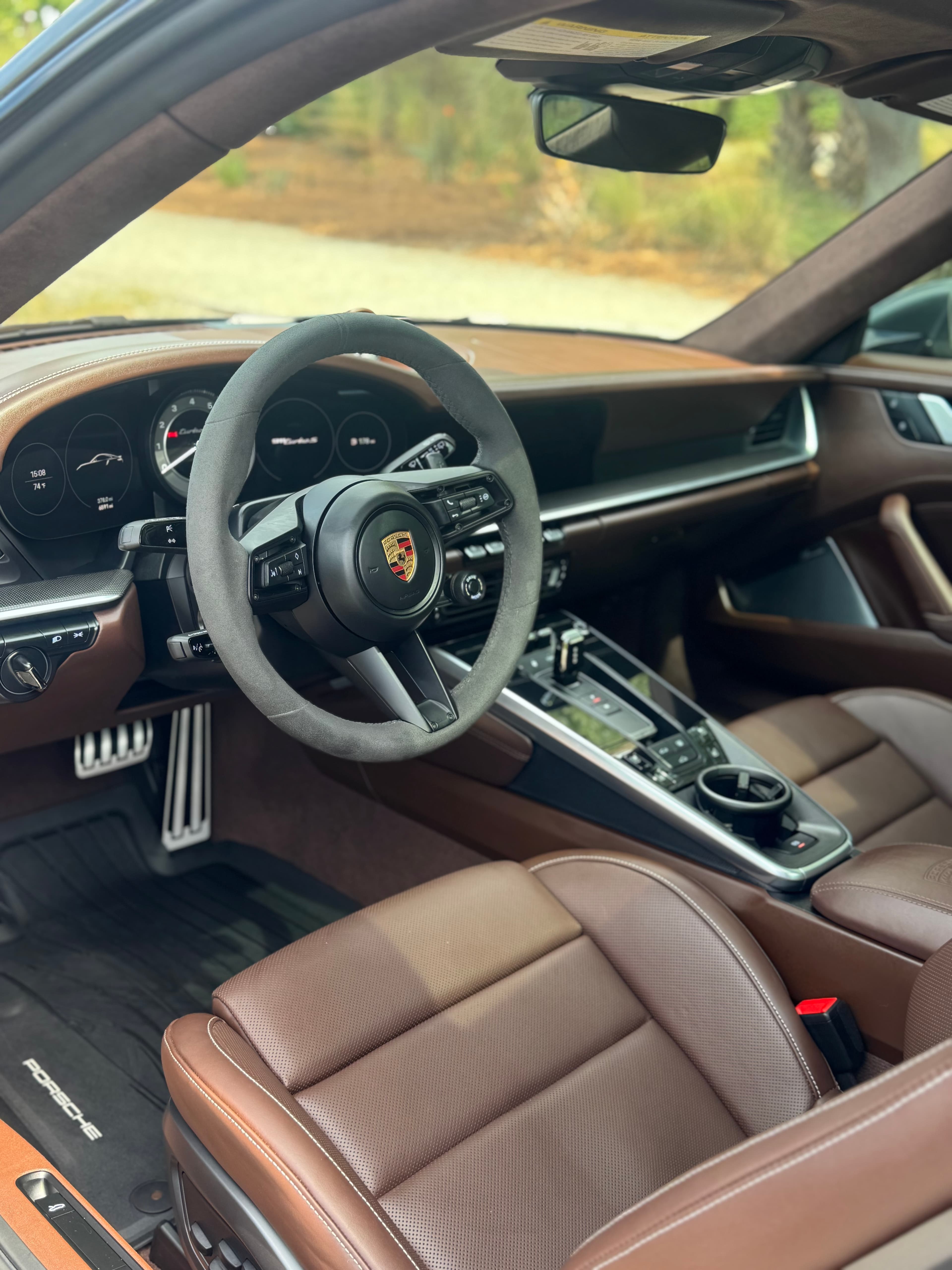 Detailed Porsche 911 interior with brown leather seats and Alcantara steering wheel
