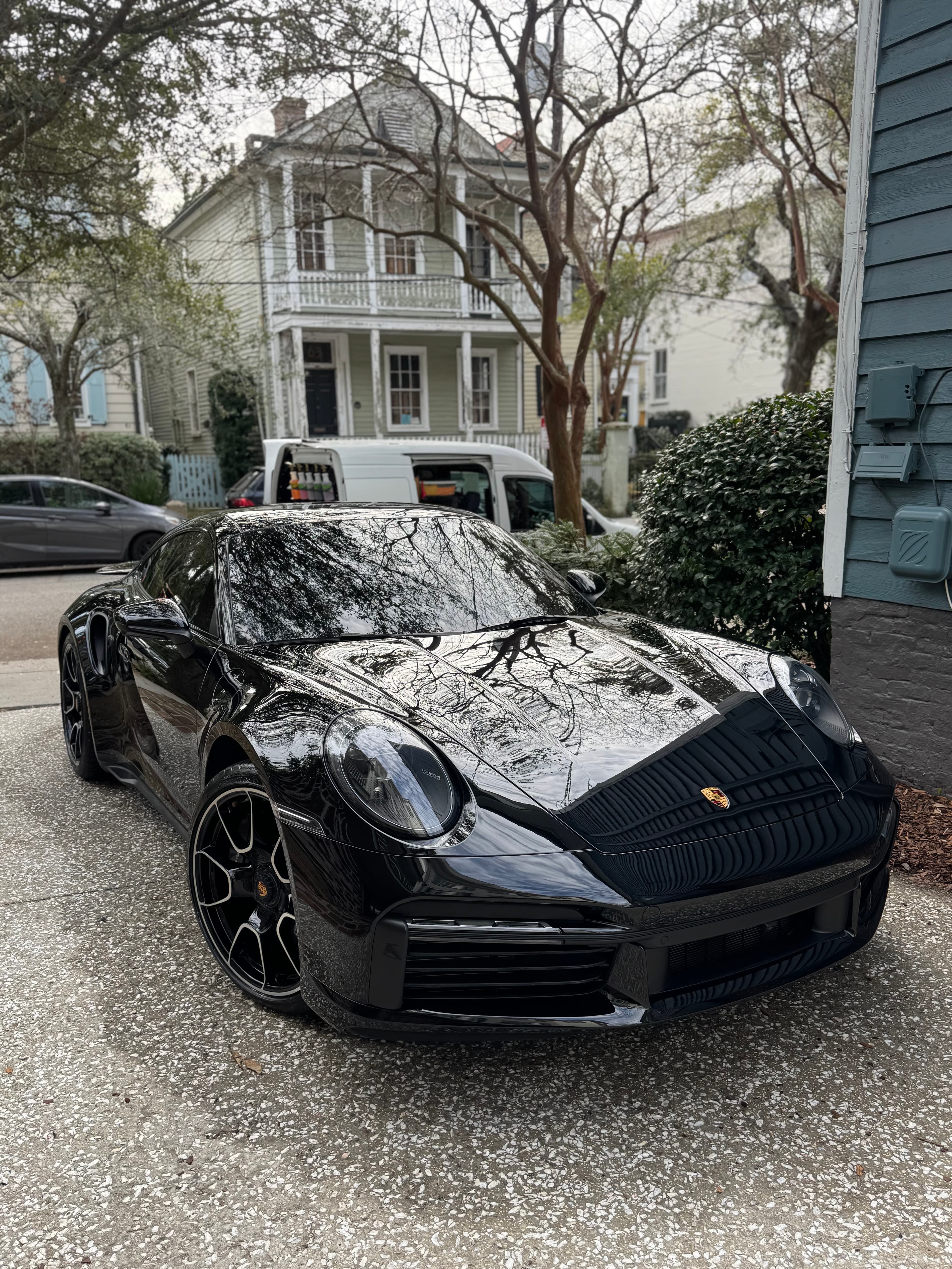 Detailed black Porsche 911 Turbo with a deep glossy finish on a Charleston street